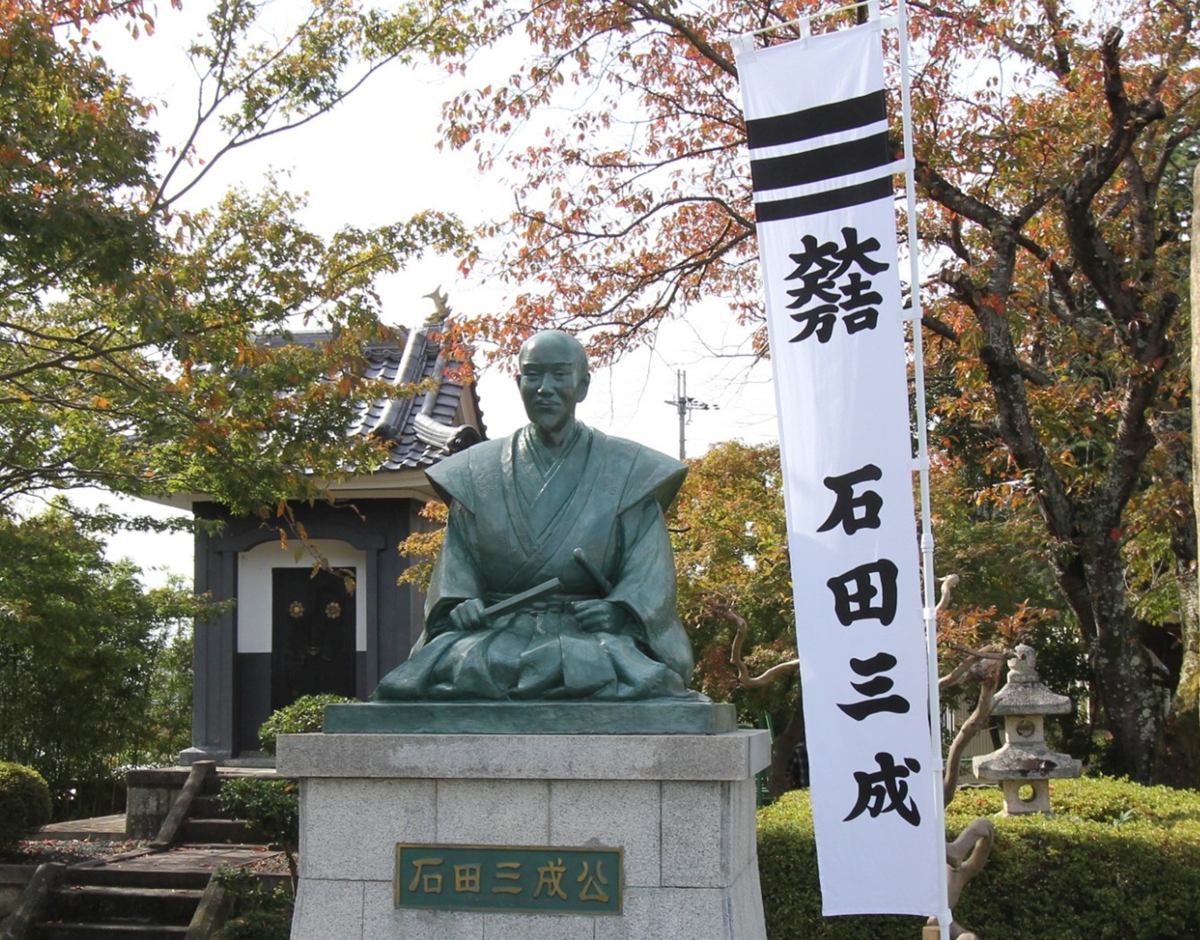 紅葉を背に立つ石田三成公の銅像
